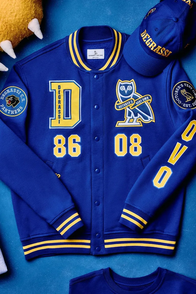 Veste bleue avec logo Degrassi et chapeau assorti, détails jaunes.
