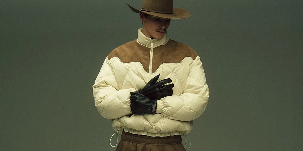 Homme en chapeau et manteau rembourré avec gants noirs