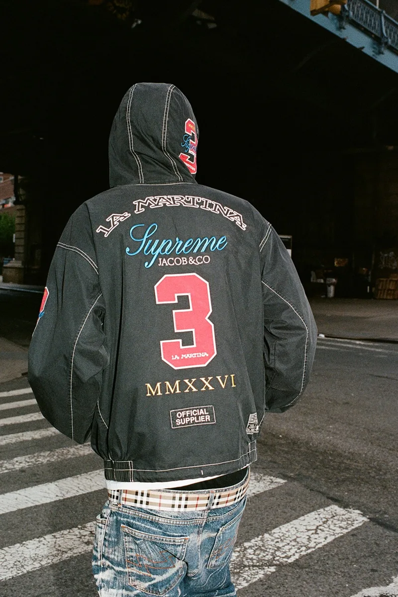 Personne avec une veste noire portant les marques Supreme et La Martina.