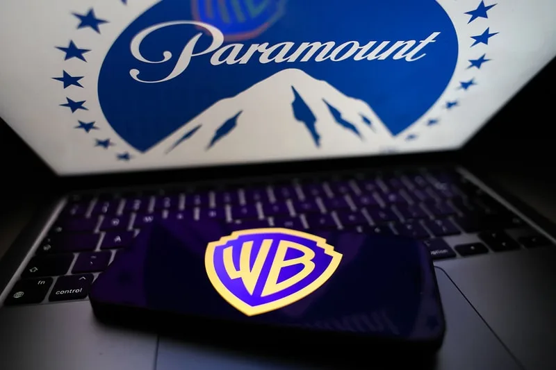 Logos Paramount et Warner Bros sur écran et smartphone. Montagne et symbole WB.