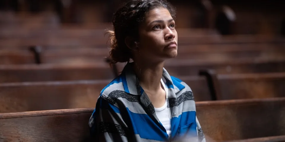 Femme assise seule dans une église, regardant vers le haut pensivement.