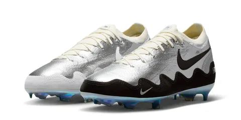 Chaussures de football argentées et noires avec semelle colorée.