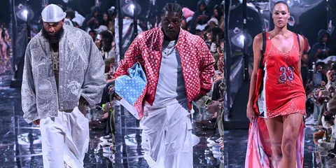 Défilé de mode avec mannequins portant des tenues variées sur le podium.