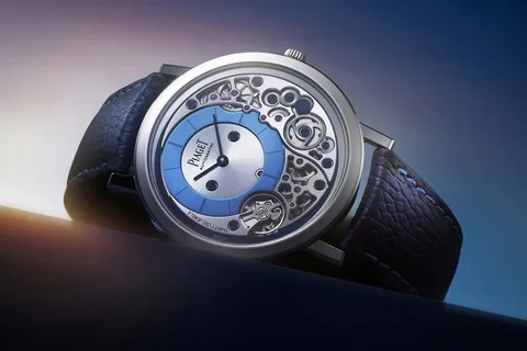 Montre de luxe avec mécanisme visible et bracelet en cuir noir.