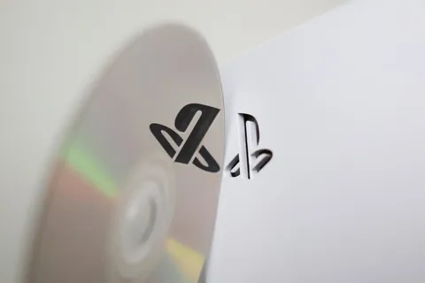 Logo PlayStation sur un disque avec une console en arrière-plan.