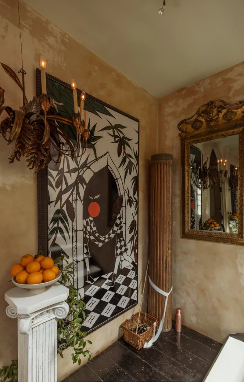 Intérieur avec affiche artistique, colonne et miroir décoratif.