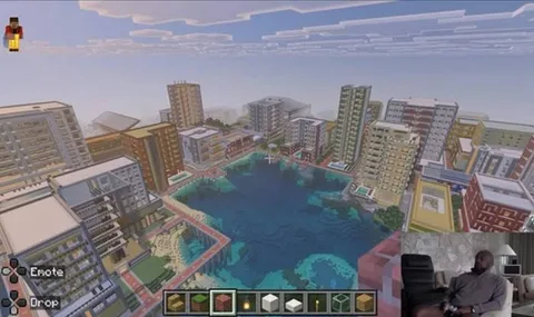 Ville Minecraft avec lac central et grands immeubles autour.