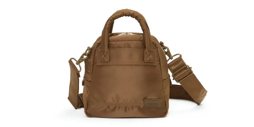 Petit sac à main marron avec sangle et poignées.
