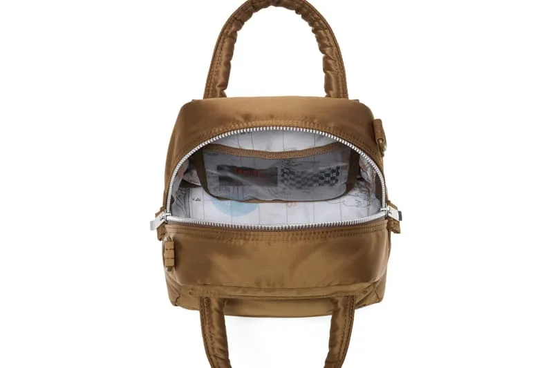 Sac à dos marron avec doublure intérieure visible, ouvert.