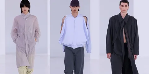 Défilé de mode avec trois mannequins en vêtements amples et modernes.