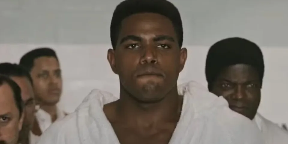 Un homme en peignoir blanc au milieu de plusieurs autres personnes.
