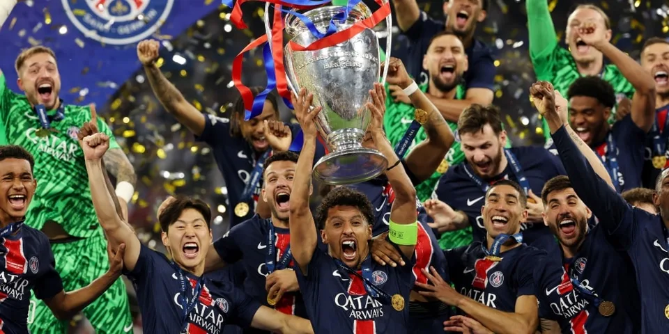 Joueurs de football célébrant avec un trophée, feux d'artifice en arrière-plan.