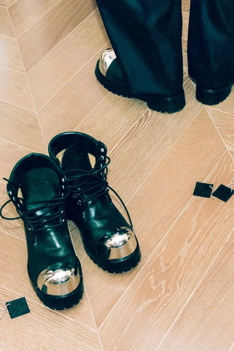 Bottes noires avec embouts métalliques sur sol en bois