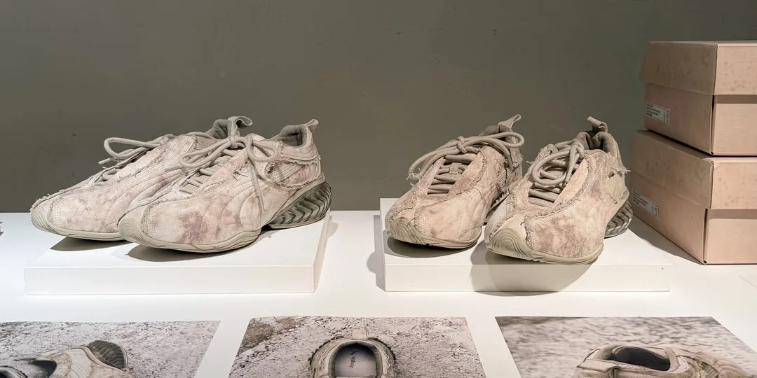 Paires de baskets beige usées exposées sur des socles blancs.