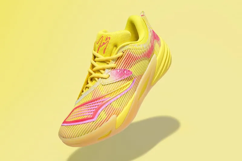Chaussure jaune et rose lumineuse en suspension sur fond jaune.