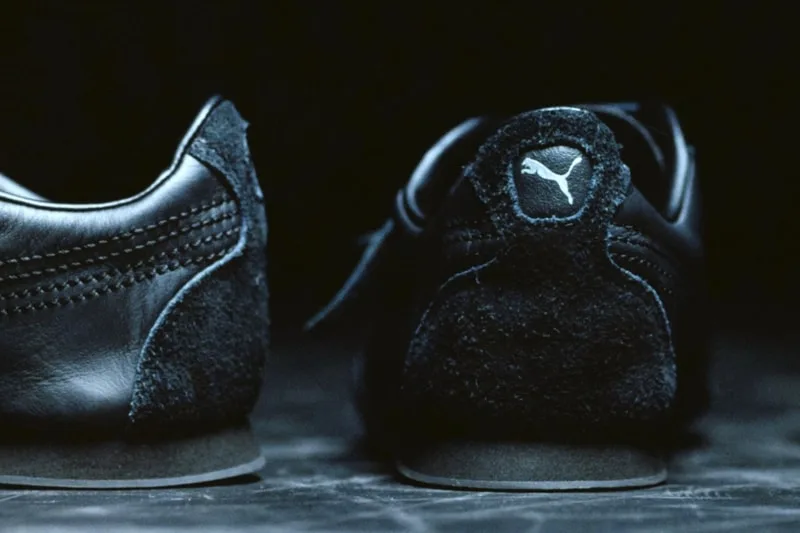 Vue arrière de baskets noires Puma avec logo sur talon.