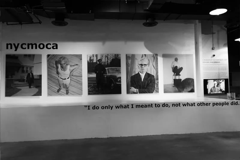Galerie avec photos noir et blanc sur le mur et citation en bas.