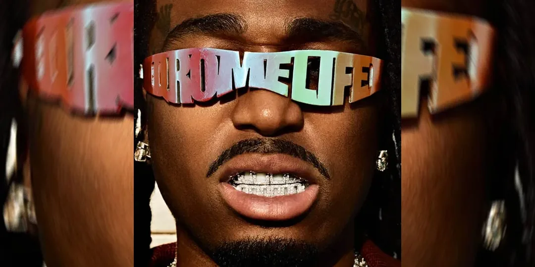 Homme portant lunettes avec texte et grillz argentés.