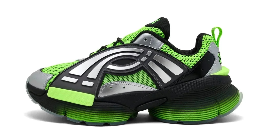 Chaussure de sport verte et noire avec détails argentés.