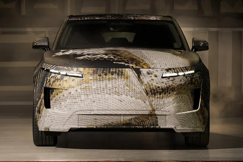 Voiture camouflée avec motif pixelisé et phares distinctifs.
