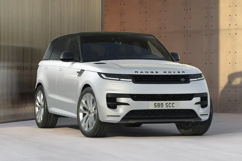 Voiture Range Rover blanche devant un mur moderne.