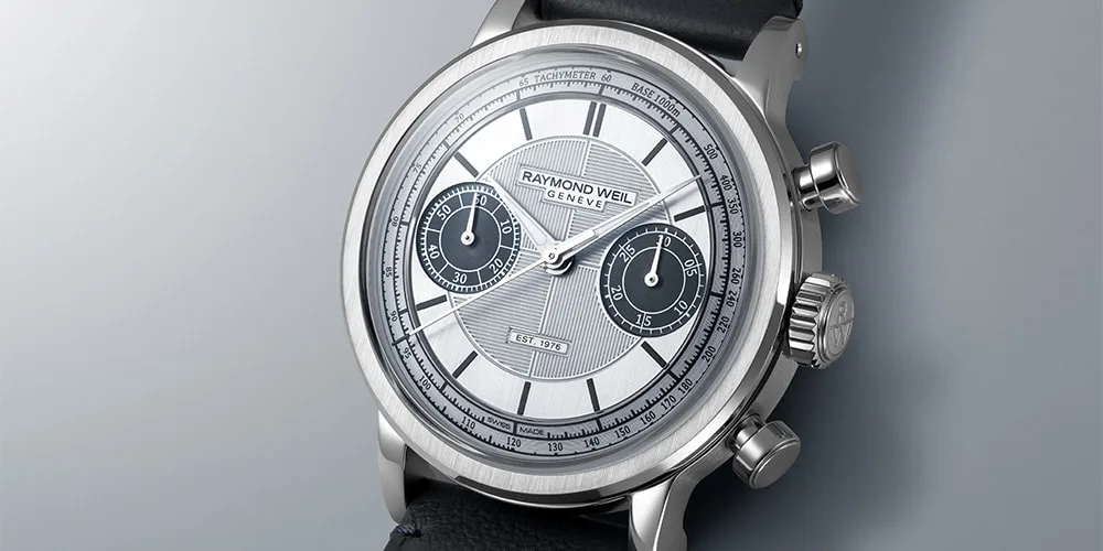 Montre argentée avec bracelet noir et cadran détaillé.