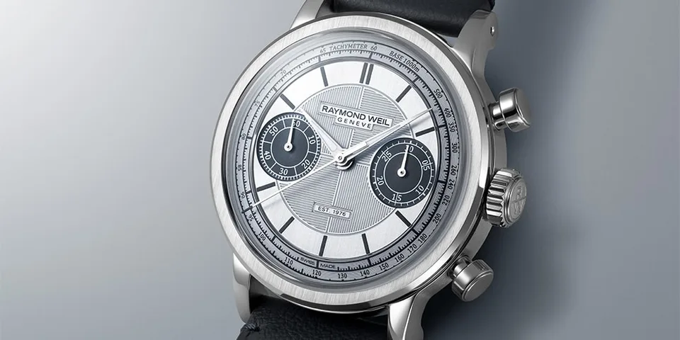 Montre argentée avec bracelet noir et cadran détaillé.