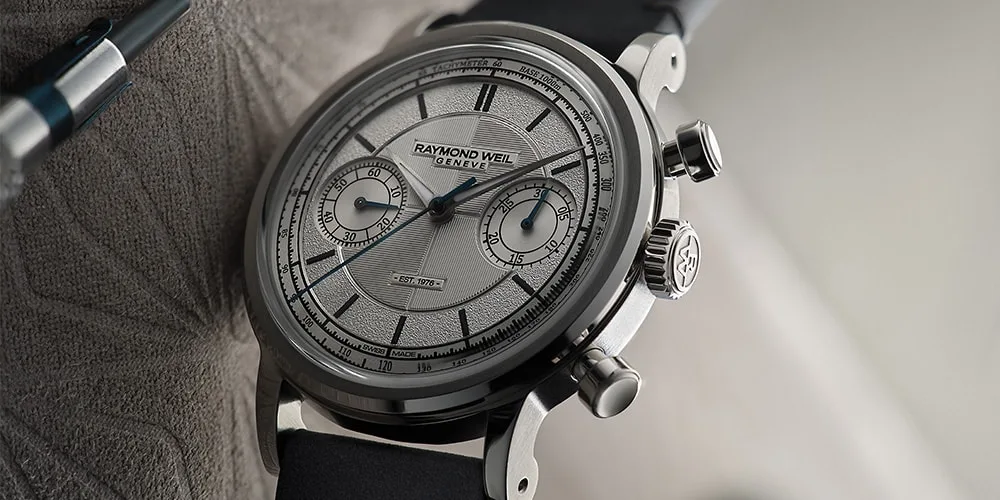 Montre design élégant avec cadran argenté et bracelet noir.