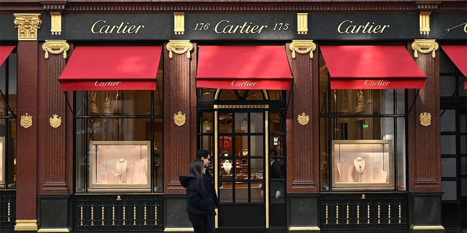 Façade de la boutique Cartier avec vitrines et auvents rouges.