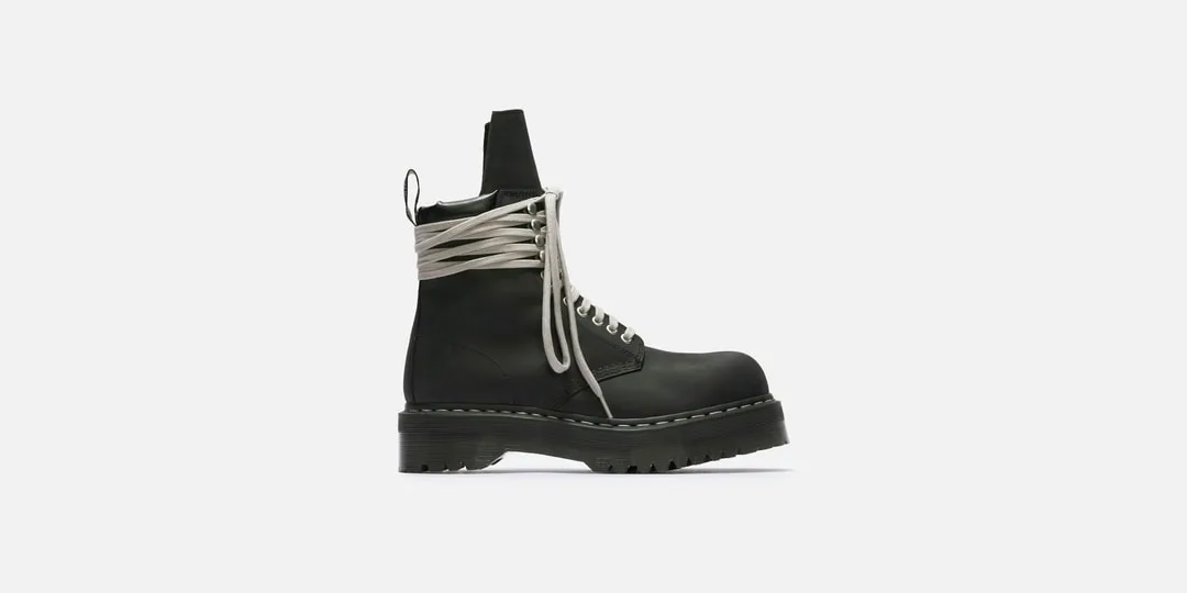 Chaussure noire avec longues lacets gris et semelle épaisse.