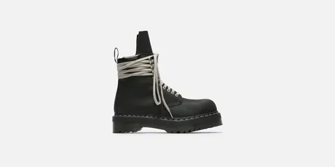 Chaussure noire avec longues lacets gris et semelle épaisse.