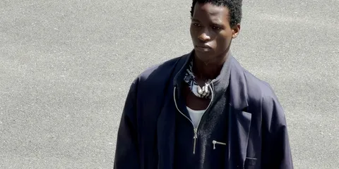 Homme en veste bleue sur fond de route grise