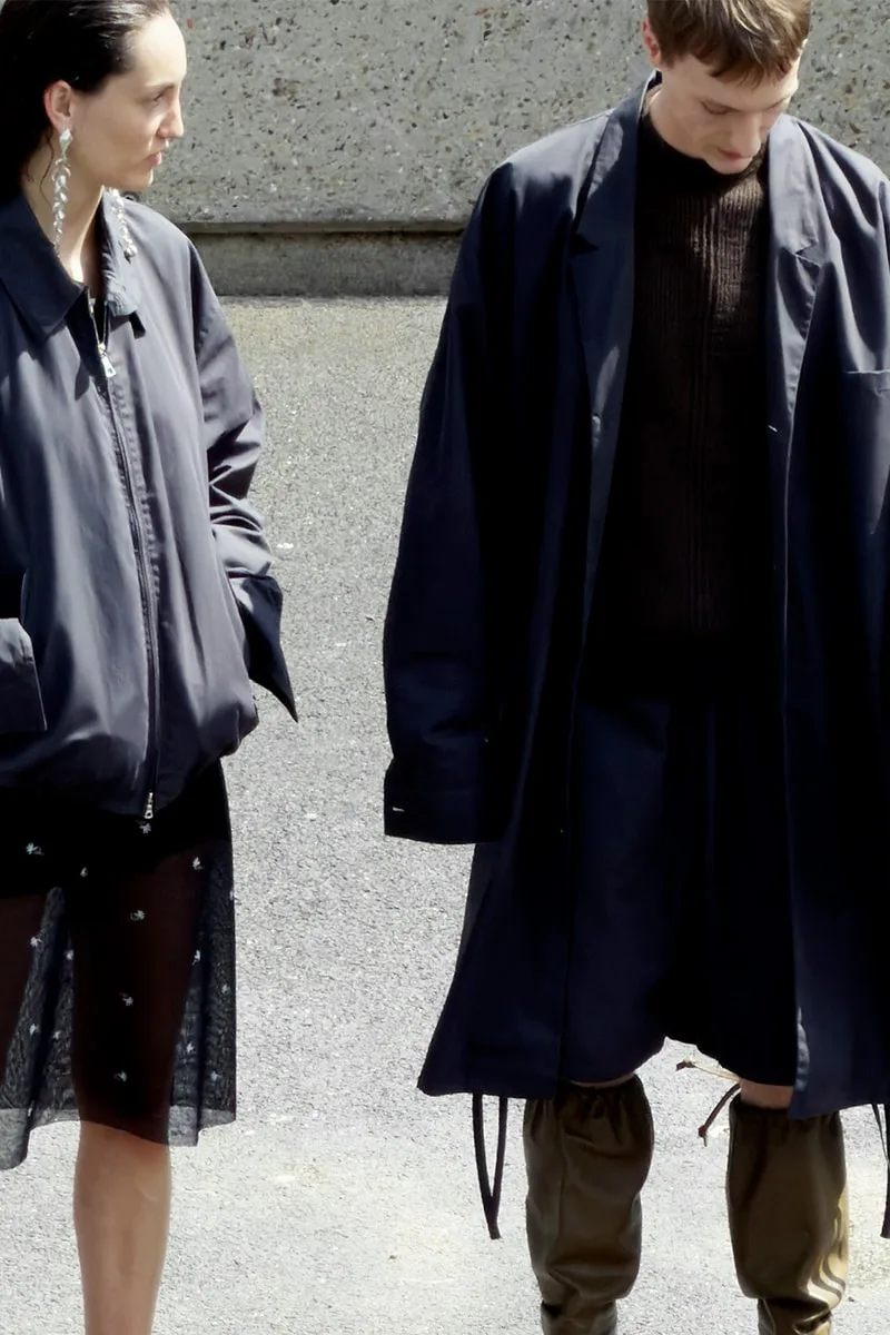 Deux personnes dans des manteaux sombres, style moderne.