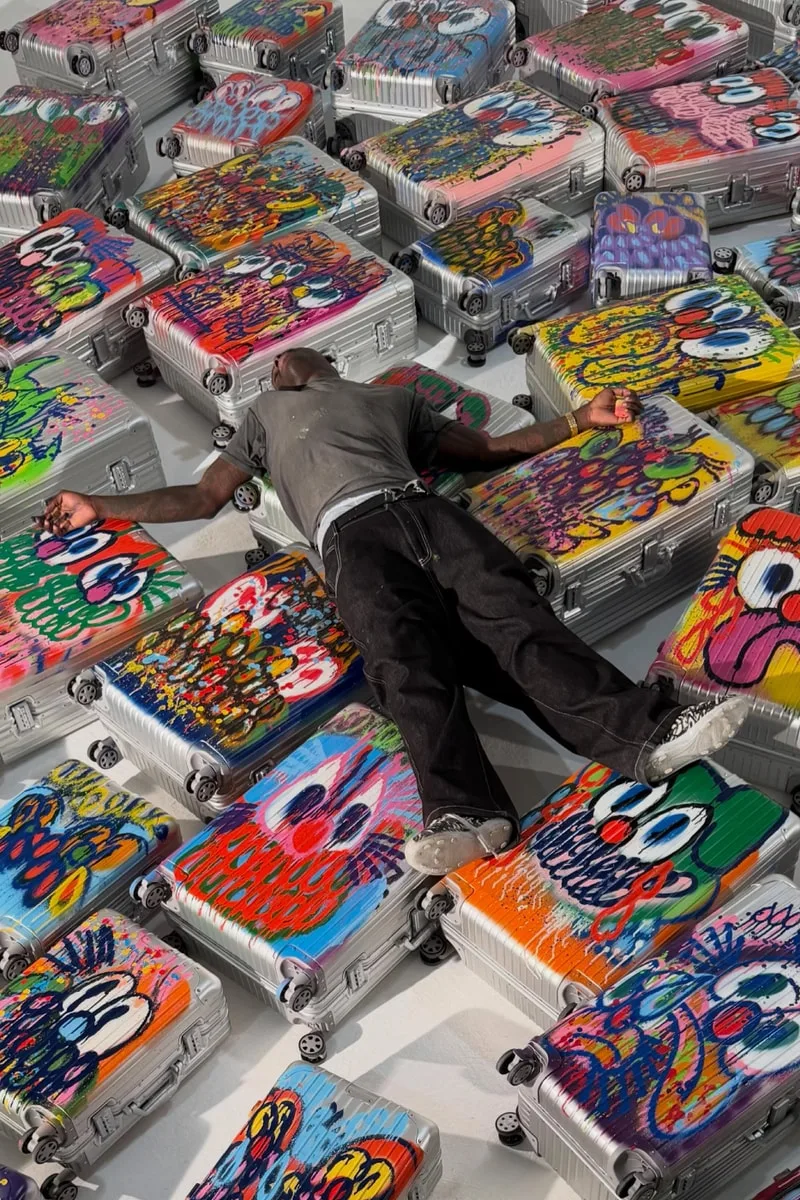 Personne allongée sur des valises peintes avec des dessins colorés.