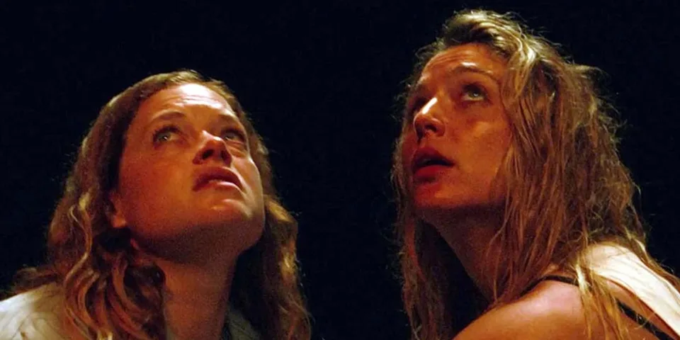 Deux personnes regardent vers le haut, expression sérieuse.