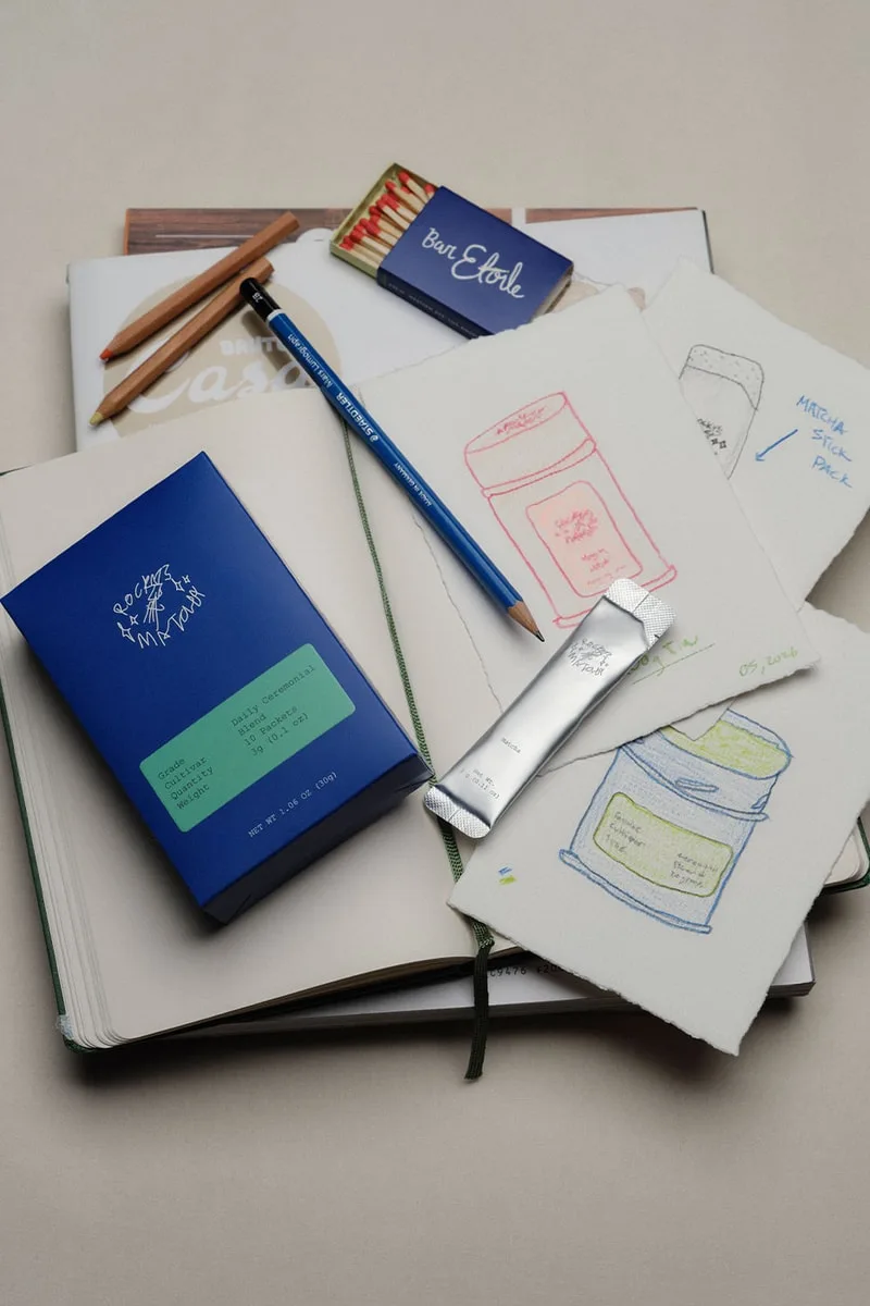 Carnet, crayons et esquisses de design cosmétique avec boîte bleue.