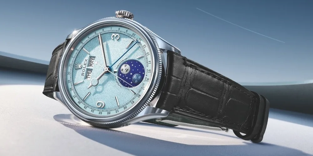 Montre élégante avec cadran bleu et bracelet noir sur fond neutre.