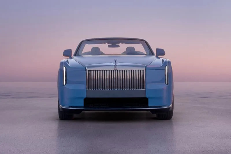 Voiture de luxe bleue au coucher du soleil.