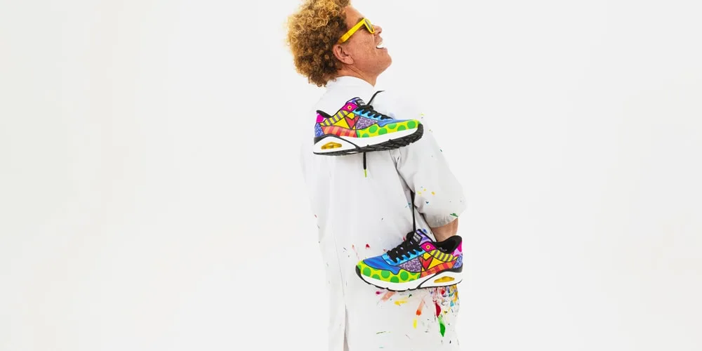Homme avec lunettes jaunes et chaussures colorées, fond blanc.