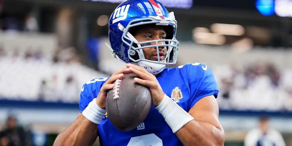 Joueur de football américain des Giants lançant un ballon.