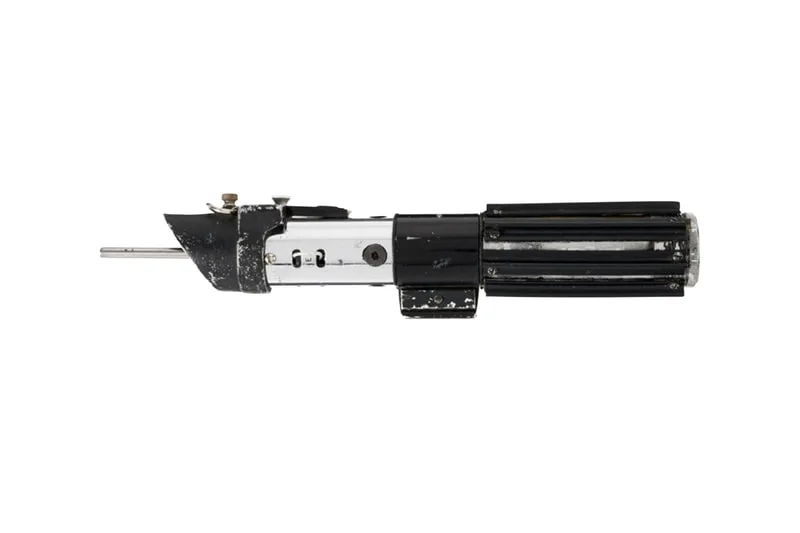 Manche de sabre laser métallique et noir sur fond blanc.