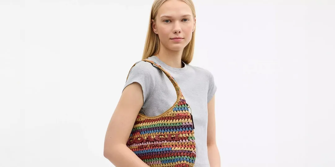 Femme avec un sac crocheté multicolore sur l'épaule.