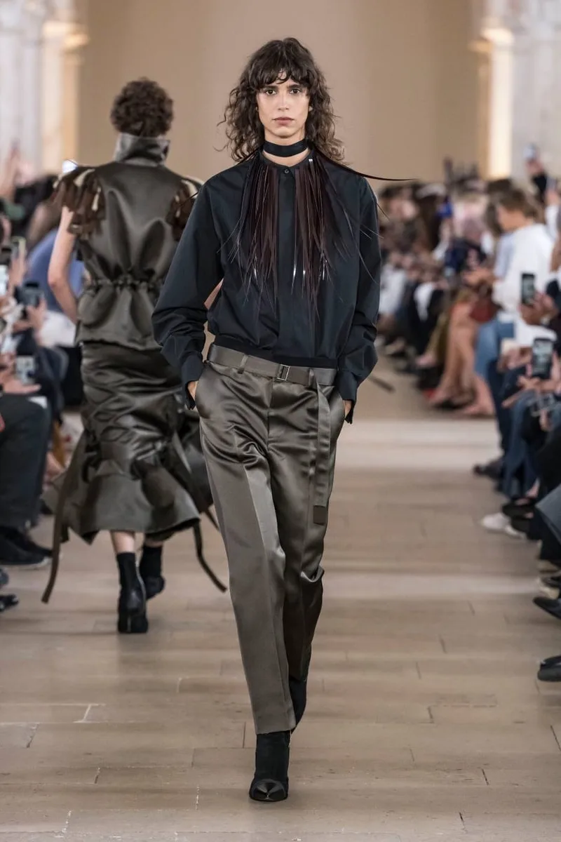 Modèle défilant en vêtements modernes dans un défilé de mode élégant.