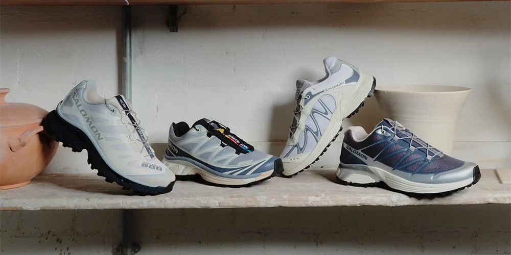 Quatre chaussures de sport alignées sur une étagère en bois.