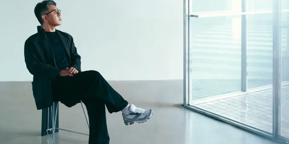 Homme assis sur une chaise, regardant par la fenêtre.