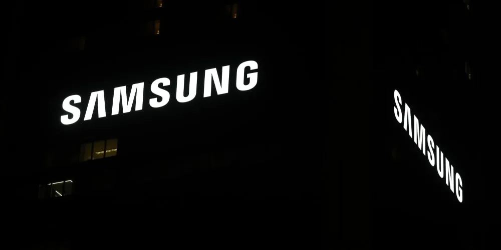 Logo Samsung lumineux sur un bâtiment la nuit.