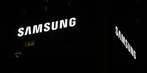 Logo Samsung lumineux sur un bâtiment la nuit.