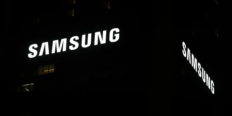 Logo Samsung lumineux sur un bâtiment la nuit.