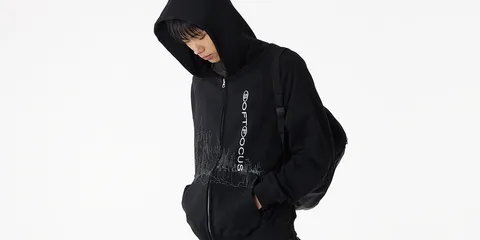 Personne en sweat à capuche noir regardant vers le bas.
