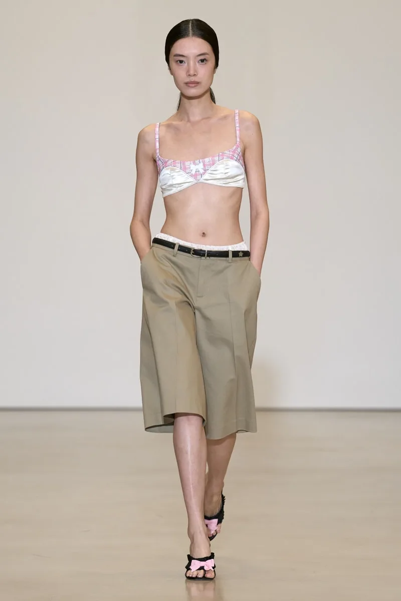 Femme défilant en haut bikini et bermuda marron clair.
